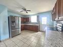 Well-lit kitchen with stainless steel refrigerator, granite countertops, and tiled floor at 1706 Reverend J.T. Menifee St, Anderson, IN 46016
