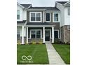 Charming two-story townhouse features a dark door, manicured lawn, and inviting facade at 19450 Northwest Dr, Westfield, IN 46074