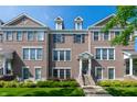 Well-kept brick townhome with a covered entry and manicured landscaping adds curb appeal to the property at 1972 Rhettsbury St, Carmel, IN 46032