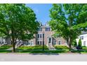 Charming townhome with a symmetrical facade, dormer windows, and neatly kept front yard between mature trees at 1972 Rhettsbury St, Carmel, IN 46032