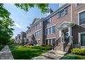 View of an attractive townhome complex with well-maintained lawns and sidewalks under a clear sky at 1972 Rhettsbury St, Carmel, IN 46032