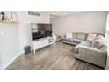Spacious living room with hardwood floors, a comfortable sofa, and a modern entertainment center at 2235 N Kenwood Ave, Indianapolis, IN 46208
