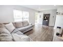 Bright living room with a large window, hardwood floors, and a comfortable sectional sofa at 2235 N Kenwood Ave, Indianapolis, IN 46208