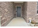 Charming entryway with a gray front door, brick walls, and decorative plants at 2330 Oak Dr, Clayton, IN 46118