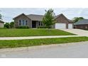 Attractive brick home with a well-kept lawn, a two-car garage, and mature trees at 2330 Oak Dr, Clayton, IN 46118