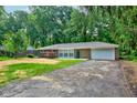 Charming brick ranch home featuring an attached garage and a tree-lined front yard at 3339 Devereaux Dr, Indianapolis, IN 46228