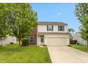 Traditional two-story home featuring vinyl siding, a two-car garage, and a welcoming front lawn at 3623 Carroll Farms Dr, Indianapolis, IN 46235