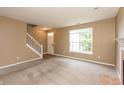 Bright living room features neutral carpeting, a staircase, and plenty of natural light at 3623 Carroll Farms Dr, Indianapolis, IN 46235
