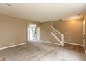 Inviting living room with neutral carpeting, staircase, and ample space for furniture at 3623 Carroll Farms Dr, Indianapolis, IN 46235