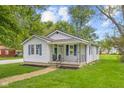 Attractive home with blue shutters and a cozy front porch, enhanced by lush green lawn at 425 Patterson Rd, Columbus, IN 47203