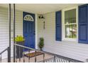 Inviting front porch featuring a bright blue door, stylish planters, and elegant black railings at 425 Patterson Rd, Columbus, IN 47203