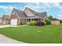 A charming single-Gathering home featuring lush green grass, mature landscaping, and a welcoming front porch at 4399 Summerhaven Dr, New Palestine, IN 46163