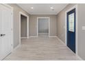 Bright entryway features wood-look tile floors, neutral walls, and a blue front door with decorative glass inserts at 4477 Devon Lake Rd, Indianapolis, IN 46226