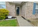 Inviting front entrance with a brick facade, walkway, manicured shrubs, and a storm door at 4528 Hunt Master Ct, Indianapolis, IN 46268