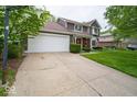 Two-story home with an attached two-car garage, red front door, and well-maintained lawn at 506 Deerberry Dr, Noblesville, IN 46062