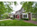 Attractive two-story home with a red door, brick accents, mature trees, and a well-manicured lawn at 506 Deerberry Dr, Noblesville, IN 46062