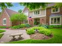 Beautiful brick home with landscaped garden beds, and a charming bench near the entryway at 5073 St Charles Pl, Carmel, IN 46033