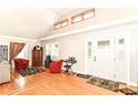 Bright living room with hardwood floors, high ceilings, large windows, and a stylish front door at 518 N Emerson Ave, Indianapolis, IN 46219