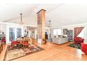 Spacious living area featuring hardwood floors, an exposed brick pillar, and an open layout perfect for entertaining at 518 N Emerson Ave, Indianapolis, IN 46219