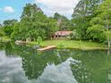 Scenic waterfront with a well-maintained lawn, dock, and charming home nestled among lush, mature trees at 5821 Bittersweet Rd, Morgantown, IN 46160