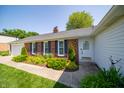 Inviting entrance with charming front door, brick accents, and meticulous landscaping at 7450 Cotherstone Ct, Indianapolis, IN 46256