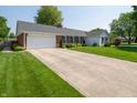 Beautiful home featuring a large driveway, two-car garage, and brick accents at 7450 Cotherstone Ct, Indianapolis, IN 46256