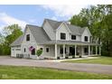 Beautiful two-story home featuring a spacious covered front porch, an attached garage, and an American flag at 8555 S County Road 375 E, Mooresville, IN 46158