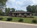 Inviting exterior of home with manicured lawn, flower beds, brick facade and attached garage at 895 W Poplar St, Zionsville, IN 46077