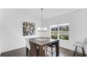 Bright dining room featuring wood floors, modern table with seating for six, and a large window at 9717 Chuckwalla Pl, Fishers, IN 46040