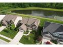 Aerial view of a well-planned community with houses surrounding a serene pond, showcasing neighborhood layout at 9903 Deep Royal Way, Indianapolis, IN 46239