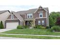 Inviting two-story home with a brick and siding facade, a lush green lawn, and mature trees at 9903 Deep Royal Way, Indianapolis, IN 46239