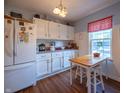 Bright kitchen featuring white cabinetry, laminate countertops, and stainless-steel appliances with dining nook at 1052 Barley Cir, Carmel, IN 46032