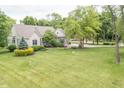 Expansive front yard with lush green grass, mature trees, and meticulous landscaping creating curb appeal at 11020 Florida Rd, Fortville, IN 46040