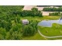 A high angle view of a home with a pond, surrounded by green space and farm fields at 12383 S 25 W, Columbus, IN 47201