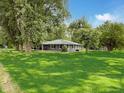 Traditional ranch style home with gray siding, mature trees, green yard, and a welcoming front porch at 12508 N Jackley Rd, Elwood, IN 46036