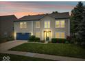 Charming two-story home featuring a blue garage door, well-maintained lawn, and manicured landscaping at 12624 Majestic Way, Fishers, IN 46037
