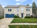 Charming two-story home featuring a blue garage door, well-maintained lawn, and manicured landscaping at 12624 Majestic Way, Fishers, IN 46037