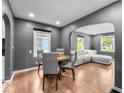 Inviting dining room with hardwood floors, neutral gray walls, and ample natural light connecting to the living room at 1331 N Berwick Ave, Indianapolis, IN 46222