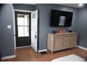 Inviting living room featuring stylish flooring, a modern entertainment center, and a screen door at 1331 N Berwick Ave, Indianapolis, IN 46222
