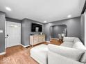 Bright living room featuring hardwood floors, neutral paint, and comfortable seating with an archway leading to the dining area at 1331 N Berwick Ave, Indianapolis, IN 46222