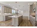 Modern kitchen boasts an island with sink, pendant lighting, and stainless steel appliances at 14878 E Keenan Cir # Lot 37, Westfield, IN 46074