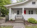 Close-up front exterior view of bungalow with brick facade, red front door, and welcoming front porch at 1617 E 52Nd St, Indianapolis, IN 46205