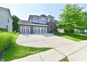 Lovely two-story home with a circular driveway, three-car garage, well manicured lawn, and mixed exterior at 18726 Tillamook E Run, Noblesville, IN 46062