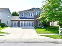 Inviting two-story home featuring a spacious driveway, three-car garage, and a well-maintained lawn at 18726 Tillamook E Run, Noblesville, IN 46062