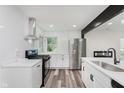 Bright kitchen featuring white cabinets, stainless steel appliances, and modern design at 233 N Devon Ave, Indianapolis, IN 46219