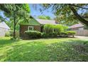 Traditional home boasts brick exterior with green trim and manicured shrubs at 2905 N Warman Ave, Indianapolis, IN 46222