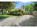 Brick home with long driveway, shingle roof, green trim and lush front landscape at 2905 N Warman Ave, Indianapolis, IN 46222