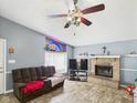 Cozy living room with a brick fireplace, ceiling fan, and natural light from the stained glass window at 3223 Keystone Lakes Way, Indianapolis, IN 46237