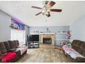 Cozy living room with a brick fireplace, ceiling fan, and natural light from the stained glass window at 3223 Keystone Lakes Way, Indianapolis, IN 46237