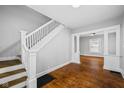 Open-concept living room with hardwood floors and staircase, perfect for entertaining at 3227 Guilford Ave, Indianapolis, IN 46205